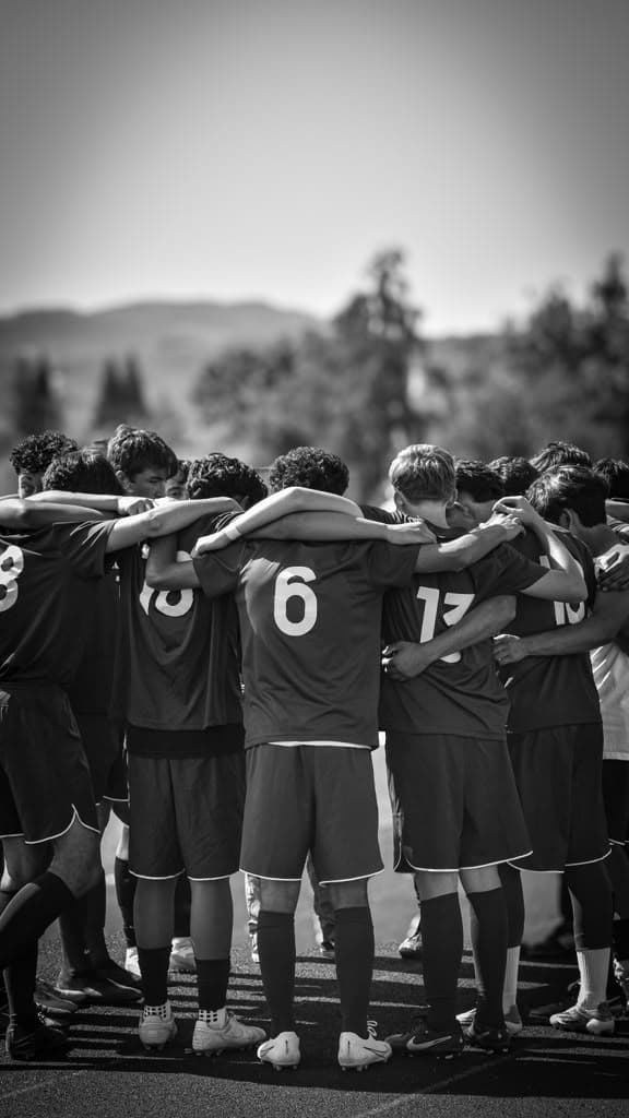 Boys Soccer huddles up before kickoff.